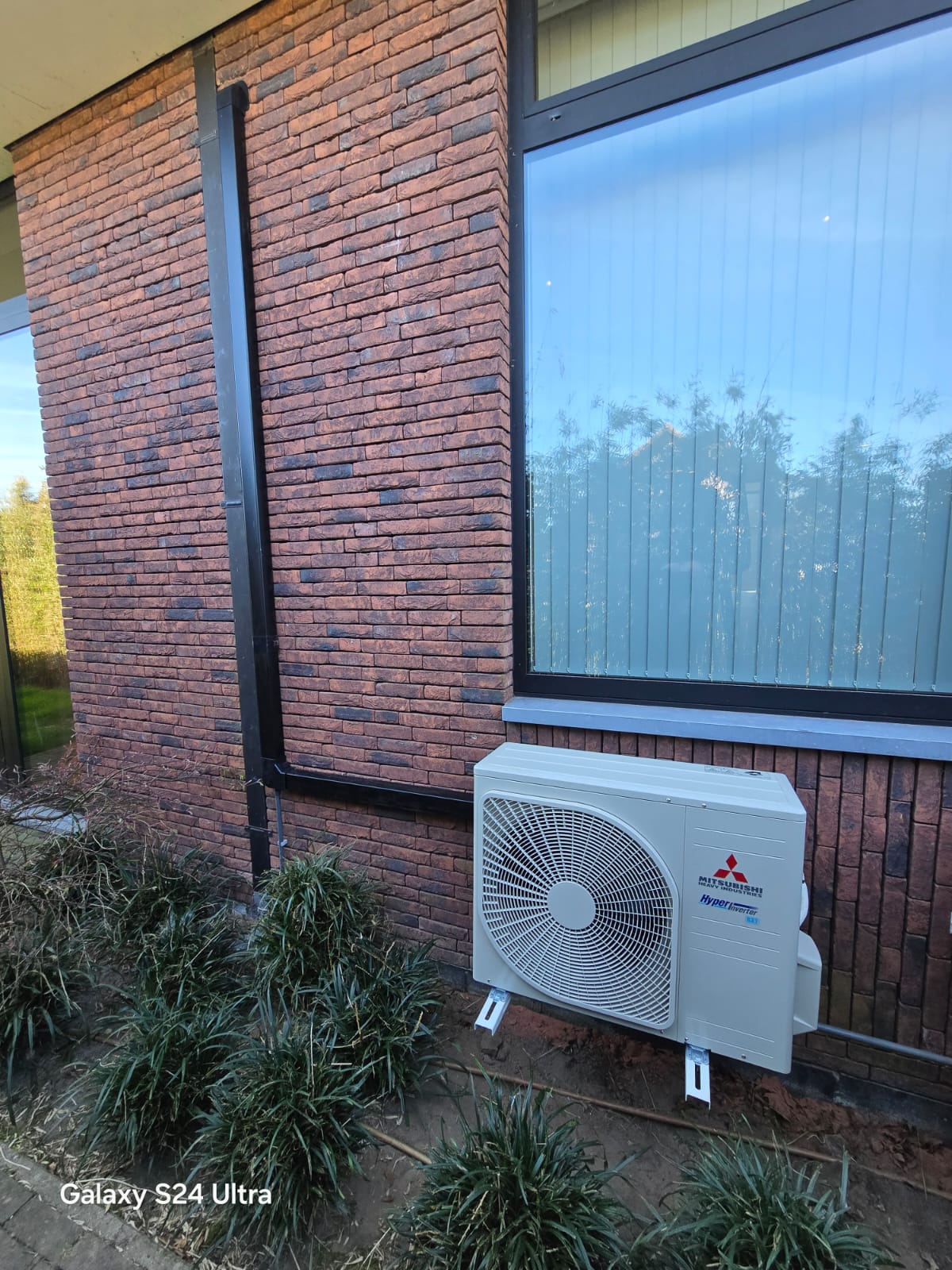 Mitsubishi airco buitenunit tegen een gevel