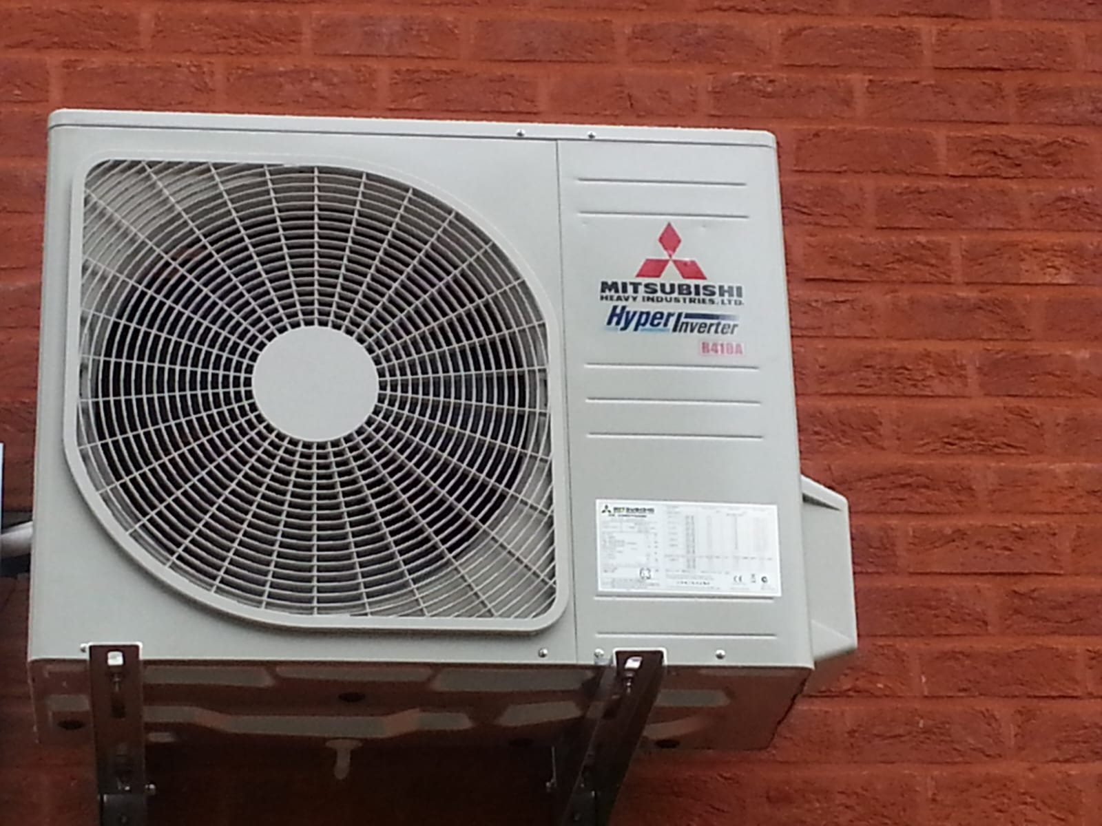 Mitsubishi buitenunit tegen een bakstenen gevel